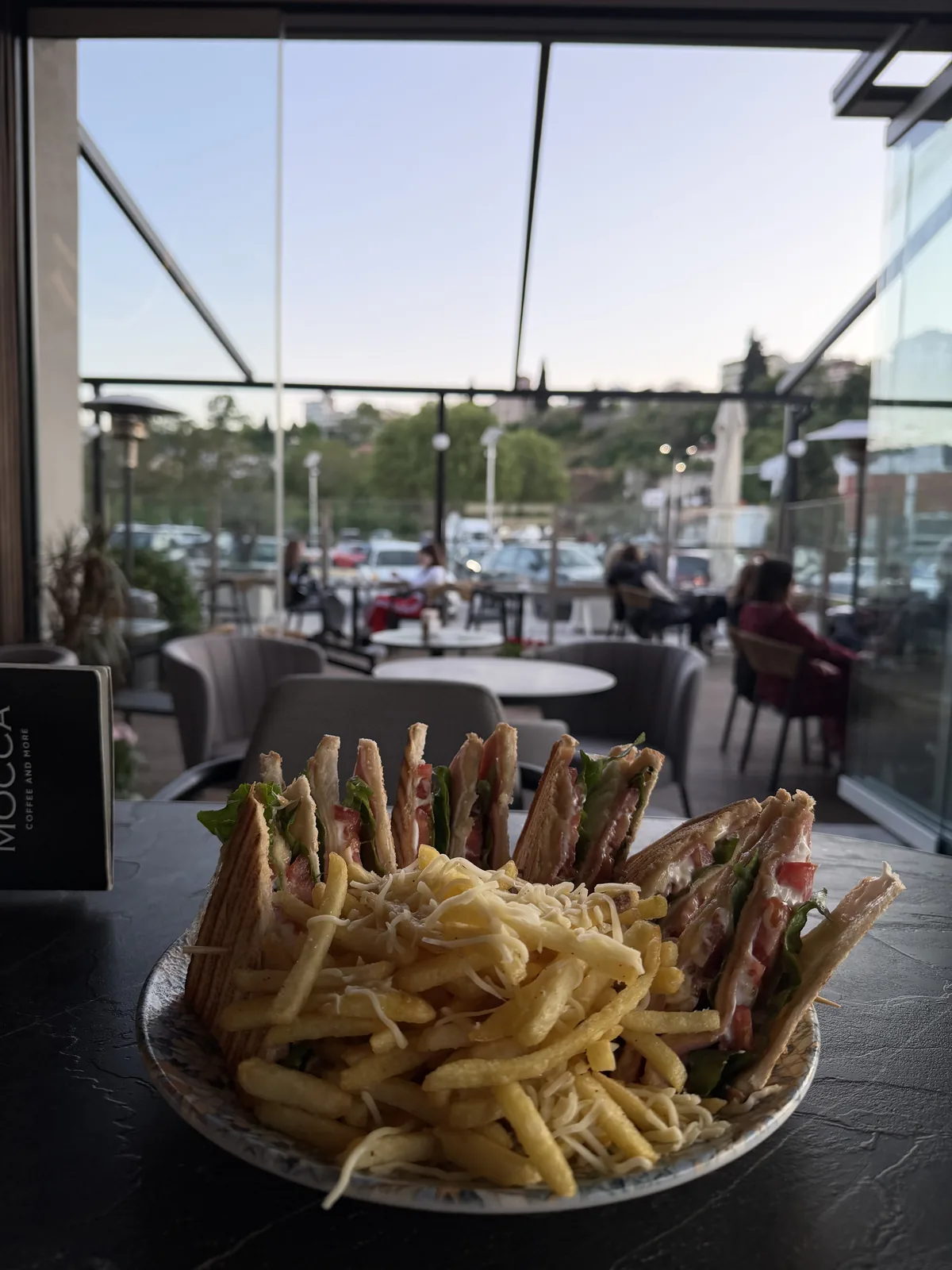 Club sandwich με πατάτες, δίπλα στο τζάμι